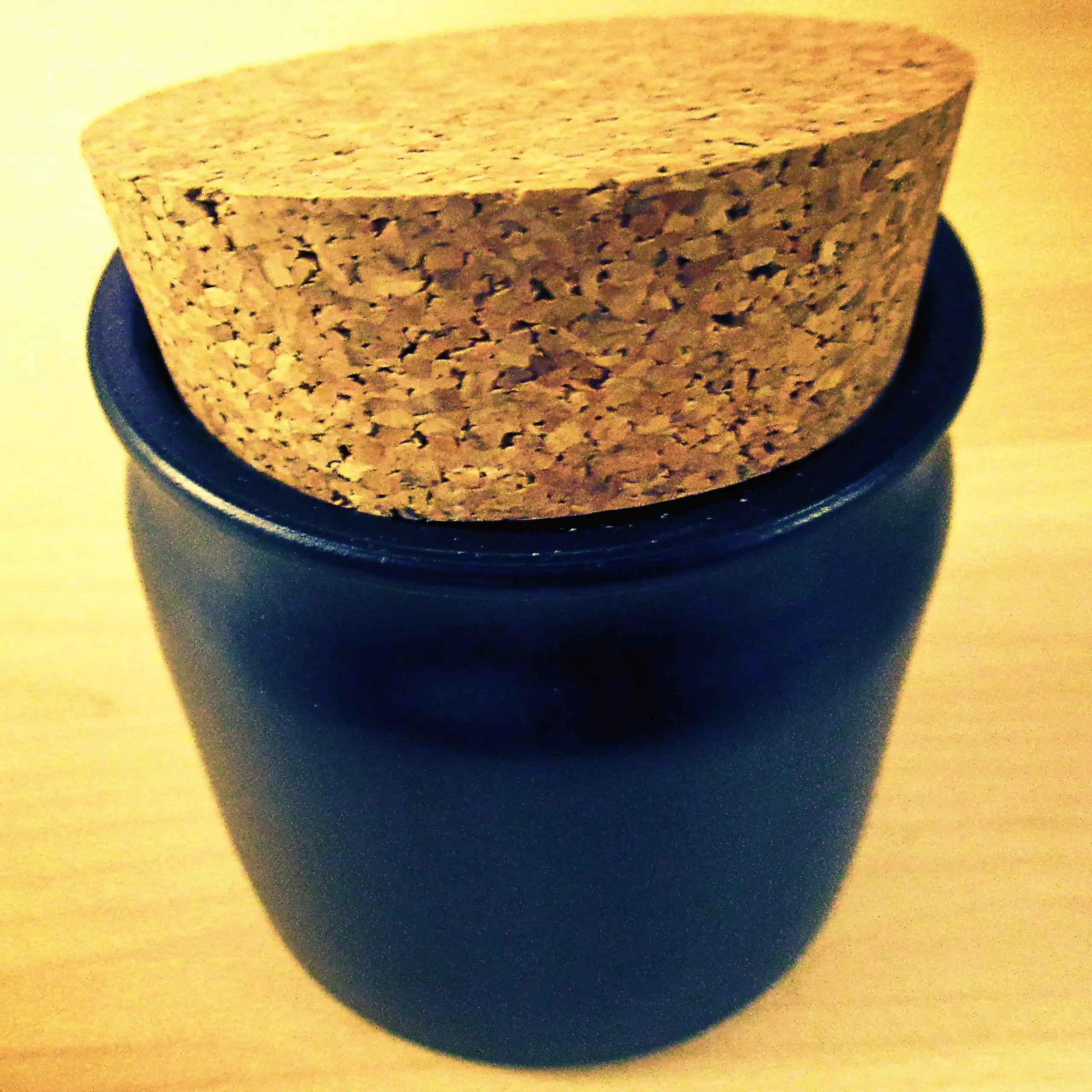 Zusätzliches Bild des Körrie-Keramik-Töpfchen: Ein geschlossenes, elegantes mattschwarzes Keramikgefäß mit natürlichem Korkverschluss, der etwas schräg aufsitzt, von oben in Nahaufnahme auf einer hellen Oberfläche für einen schlichten, funktionalen Look p