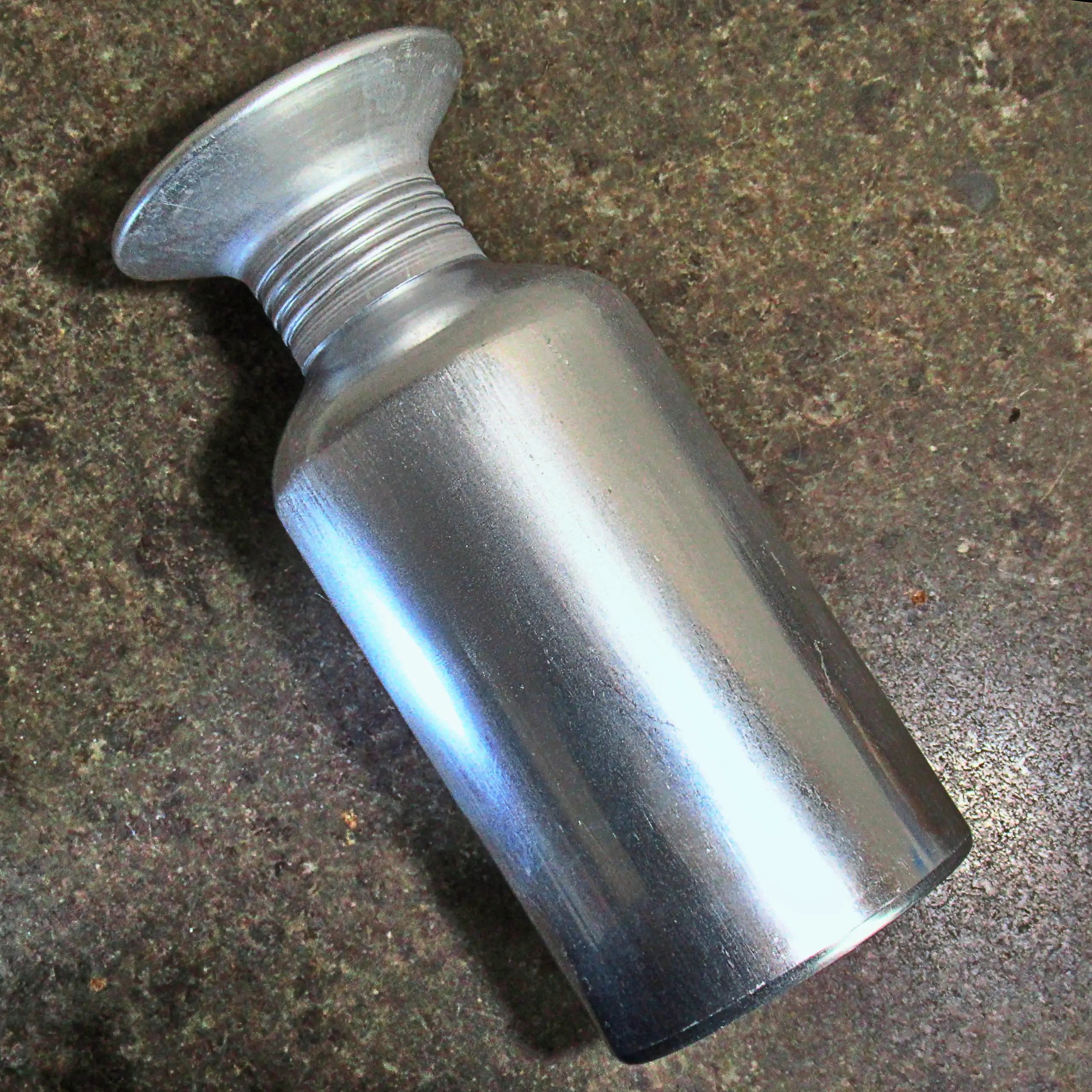 Detailaufnahme des Körrie-Gewürz-Streuer (Körrie KGS): Ein robuster, ergonomisch gestalteter Streuer mit aufgeschraubtem Deckel, liegend präsentiert auf einer dunklen Arbeitsfläche aus Jura-Marmor für einen detaillierten, hygienischen und ansprechenden Ei