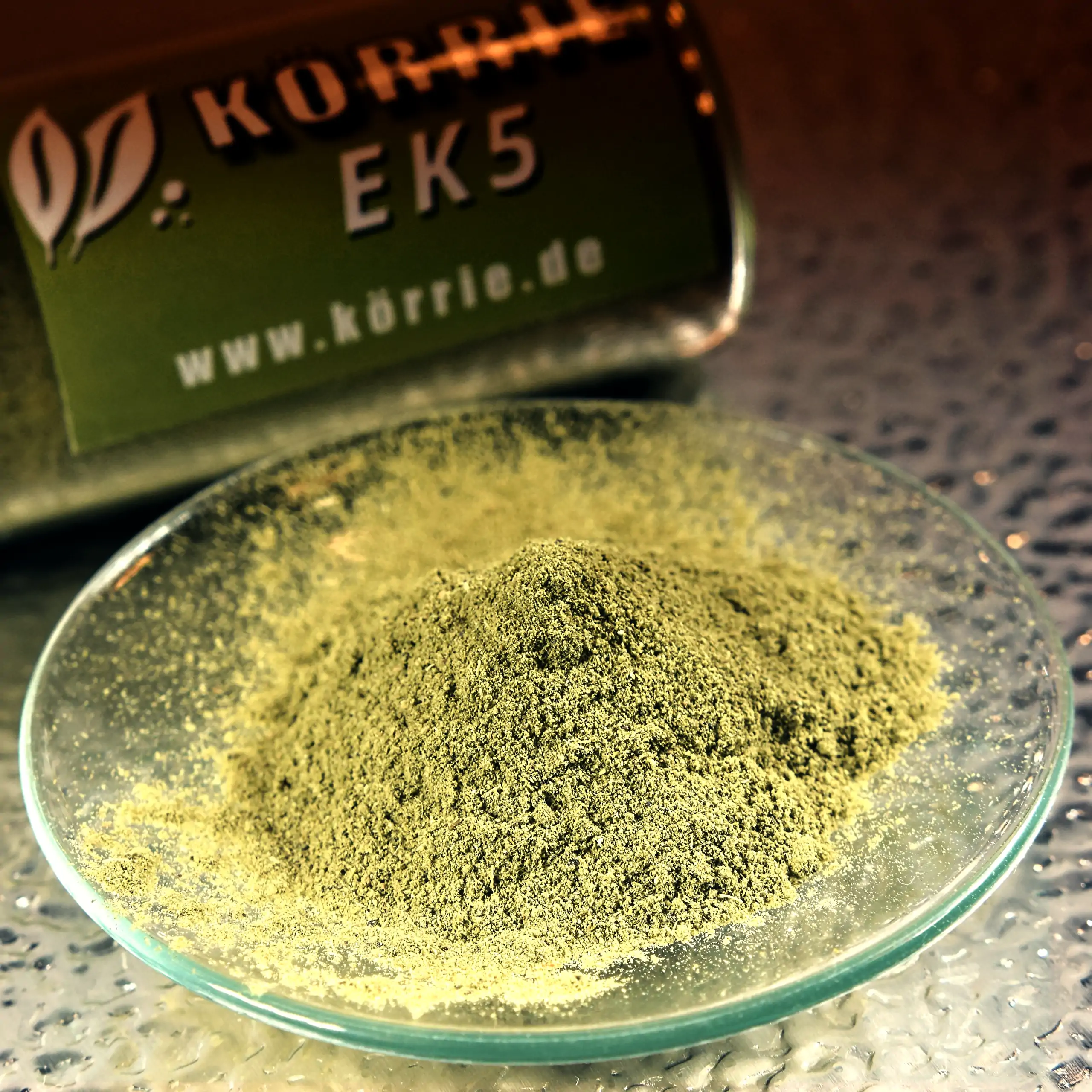 Ergänzendes Bild der Körrie EK5 Gewürzmischung: Ein Haufen leuchtend gelb-grüner, extra feinpulvriger Kräutermischung in einer transparenten Glasschale auf silbernem Hintergrund, der die hochkonzentrierte, geschmacksintensive Textur betont für einen frisc