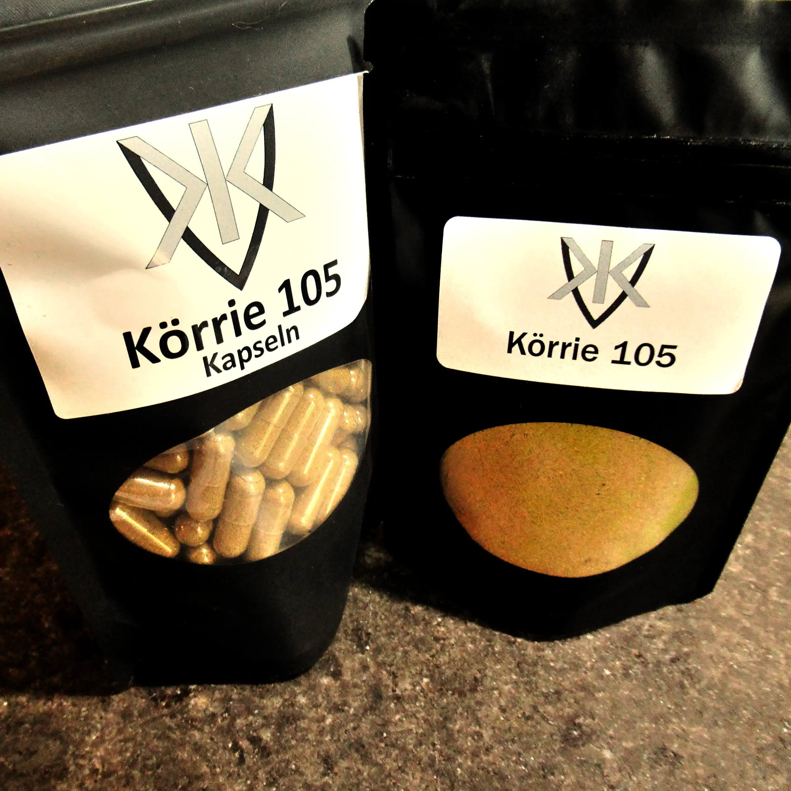 Alternatives Vorschaubild der Galerie für Körrie 105 Kapseln: Zwei schwarze Beutel mit transparentem Sichtfenster, einer gefüllt mit goldenen veganen Kapseln und der andere mit fein gemahlener goldgelber Currypulver-Mischung, versehen mit weißen Labels, d