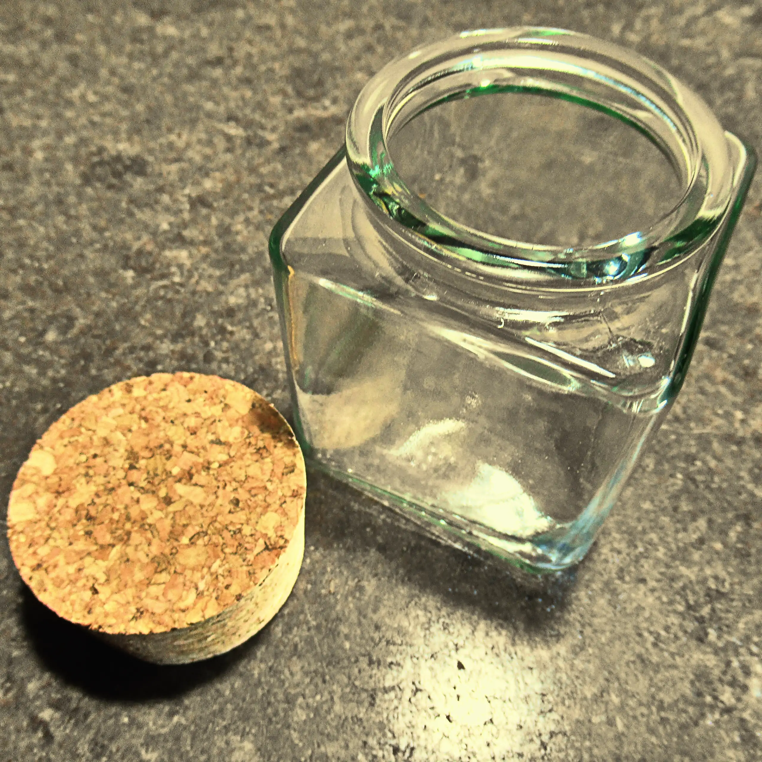 Alternatives Vorschaubild der Galerie für Körrie-Korken-Glas / Körrie KKG: Ein elegantes, quadratisches Glasgefäß mit natürlichem Korkverschluss, offen präsentiert mit dem Korken daneben auf einer rustikalen Oberfläche für einen transparenten, funktionale